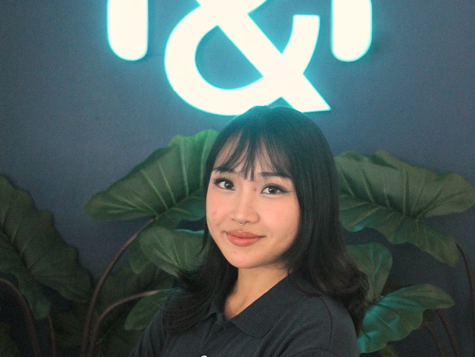 A Desk & VA team member in front of the Desk & VA logo at the Downtown office