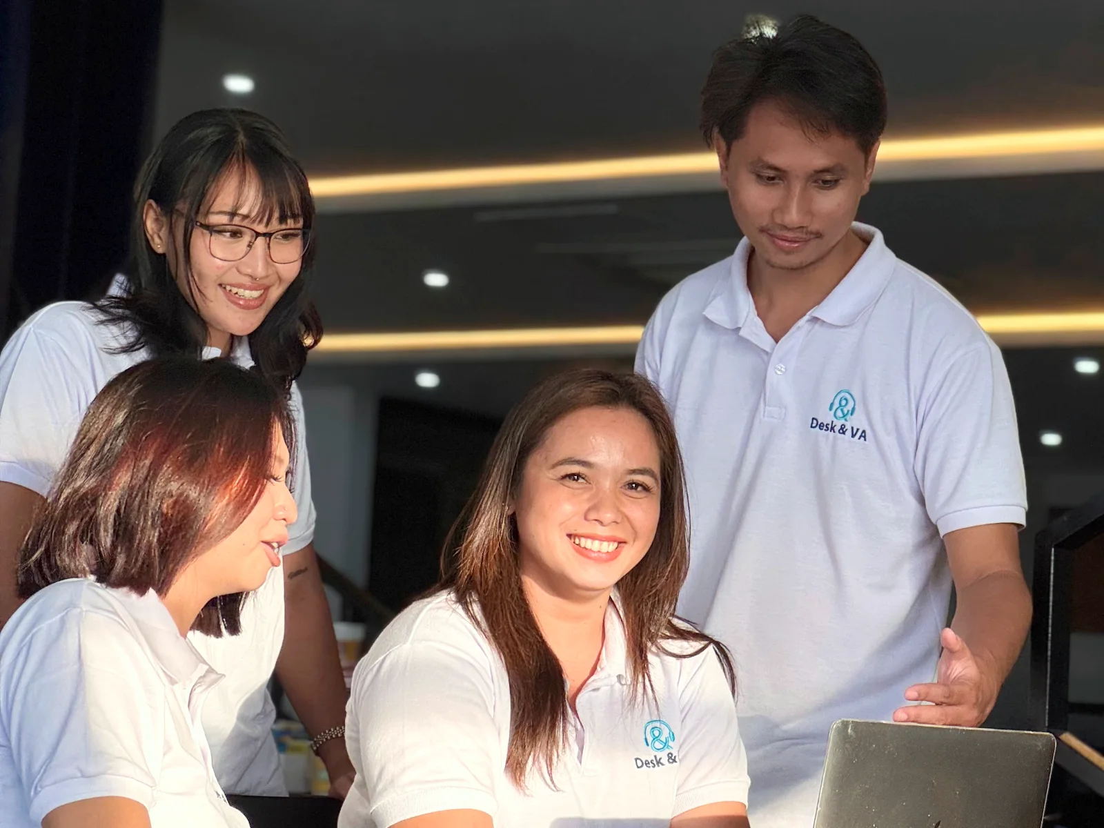 Desk & VA assistants working together around a laptop in the Downtown office
