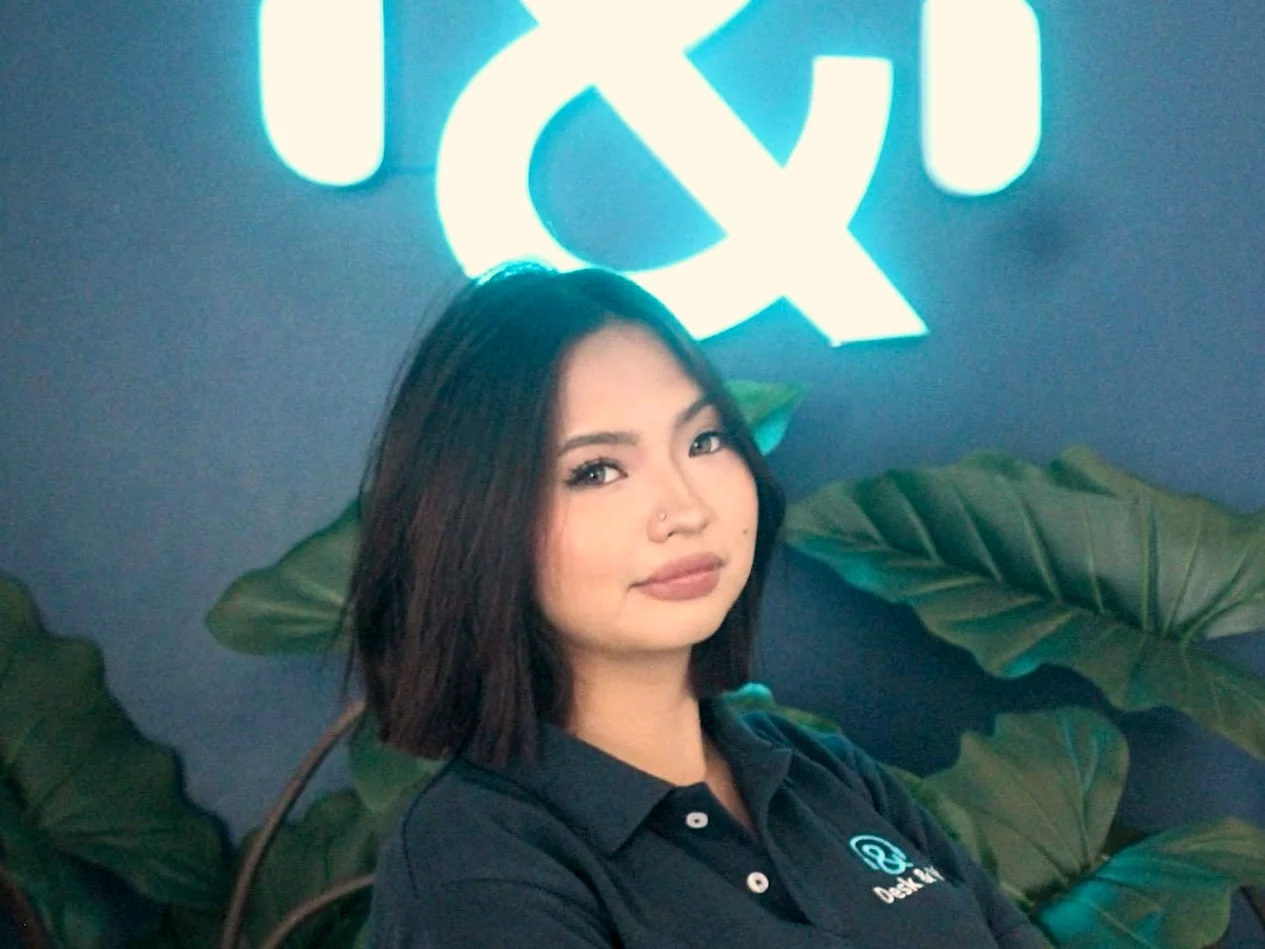 A Desk & VA team member in front of the illuminated Desk & VA logo